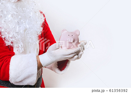 piggy bank in hands of Santa Claus on a white background piggy bank in hands of Santa Claus on a white background 61356392