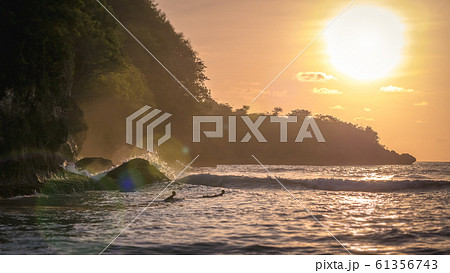 Local Kids surf on Waves in Sunset light, Beautiful Crystal Bay, Nusa Penida Bali 61356743