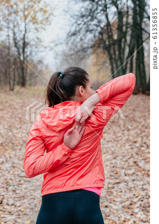 Young woman stretching before her run outdoors on a cold autumn day 61356855