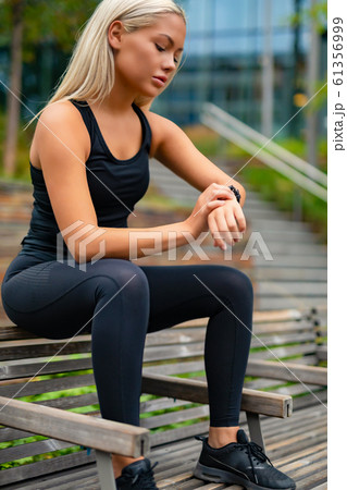 Female runner on mobile smart phone app tracking progress for motivation 61356999