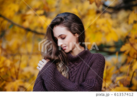 Romantic young woman in autumn park. Warm sunny weather. Fall concept 61357412