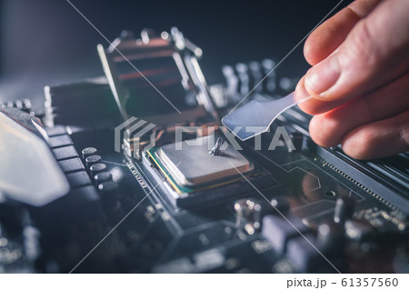 Application of thermal paste on the laptop processor chip for high-quality cooling. Spreading thermal compound to iprove cooling performance. Upgrade or PC repair concept. 61357560