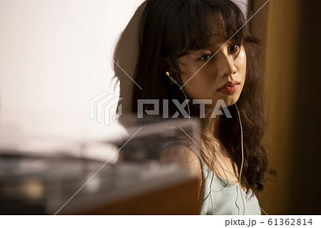 音楽を聴いて黄昏れる女性 61362814