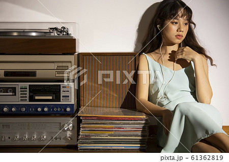 音楽を聴いて黄昏れる女性 61362819