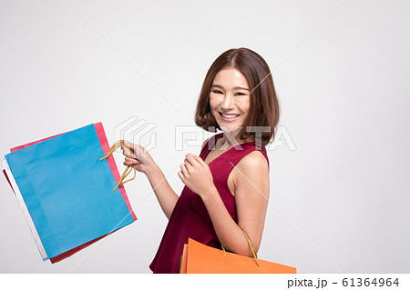 Shopping Asian woman with short hairs smile wearing red dress Holding Shopping bags,Cheerful and Happiness enjoy shopping in black friday sale,Isolated on gray background Shopping Asian woman with short hairs smile wearing red dress Holding Shopping bags,Cheerful and Happiness enjoy shopping in black friday sale,Isolated on gray background 61364964