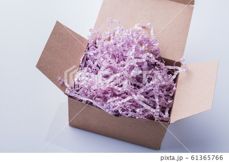 Cardboard box overfilled with shredded paper. 61365766