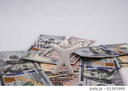 ドル札の上に乗って喜ぶ人　横位置　白背景 61365966