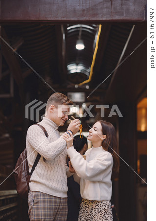 newlywed couple eating noodles with chopsticks in Shanghai outside a food market newlywed couple eating noodles with chopsticks in Shanghai outside a food market 61367997