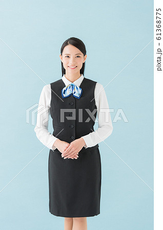 制服を着た女性 青背景 縦位置 の写真素材