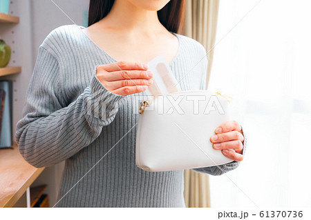 ポーチに絆創膏を入れる女性 ポーチに絆創膏を入れる女性 61370736