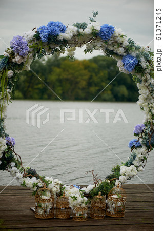 Round arch with white and blue flowers. Check-out on the river or lake.Wedding registration. 61371245