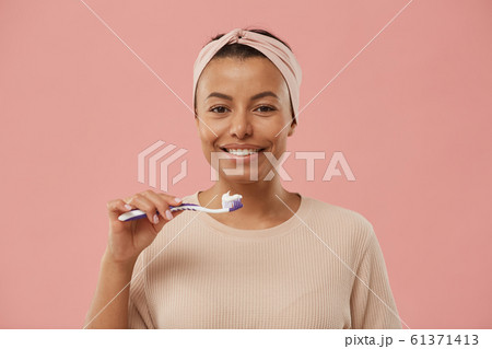Beautiful Mixed-Race Woman Brushing Teeth 61371413