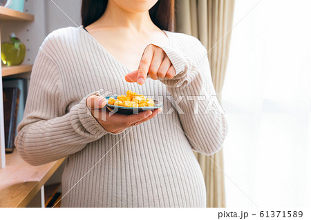 おかきを食べる妊婦 おかきを食べる妊婦 61371589