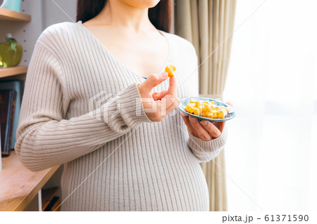おかきを食べる妊婦　悩む 61371590