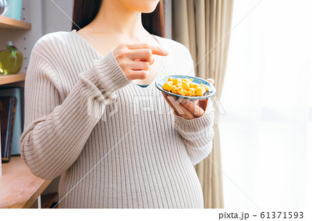 おかきを食べる妊婦 おかきを食べる妊婦 61371593