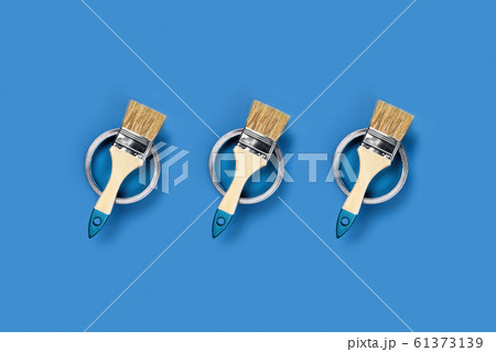 Blue background with paint jars and brushes. 61373139