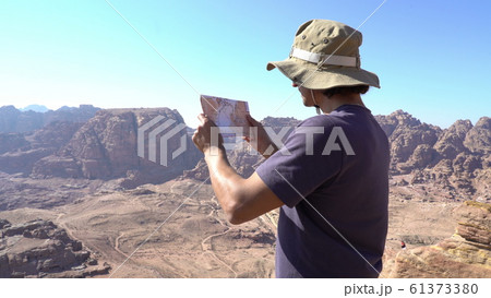 Hiker looking at map from mountain top Aerial shot Hiker looking at map from mountain top Aerial shot 61373380