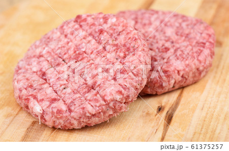Soft focus. Raw pink beef cutlet isolated on a cutting board. Soft focus. Raw pink beef cutlet isolated on a cutting board. 61375257