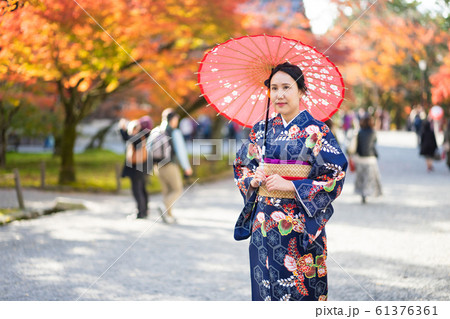 Geishas girl wearing Japanese kimono among red Geishas girl wearing Japanese kimono among red 61376361