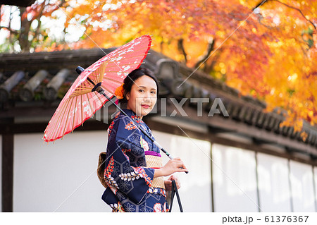 Geishas girl wearing Japanese kimono among red Geishas girl wearing Japanese kimono among red 61376367