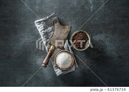 Old meat butcher on dark concrete board with Old meat butcher on dark concrete board with 61376739