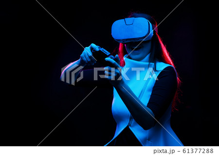 Woman with virtual reality headset is playing game. Woman with virtual reality headset is playing game. 61377288