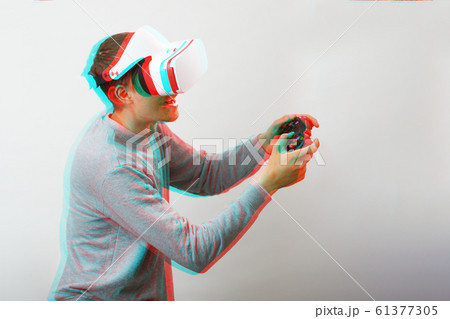 Man with virtual reality headset is playing game. Image with glitch effect. 61377305