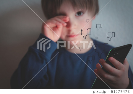 Cyber bullying concept - depressed boy with phone and negative comments 61377478