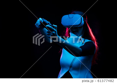 Woman with virtual reality headset is playing game. Woman with virtual reality headset is playing game. 61377482