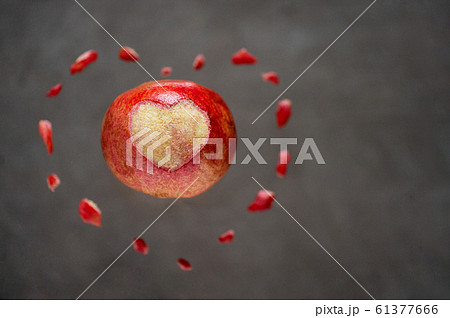 Pomegranate fruit peeled heart on grey background 61377666