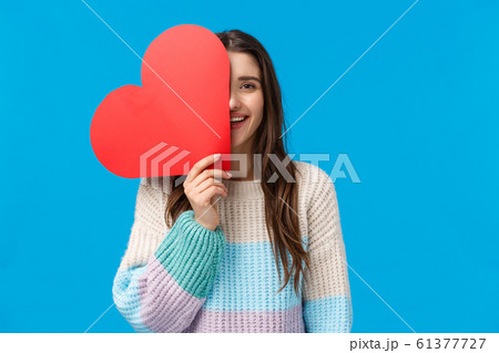 Time to say i love you. Cheerful dreamy and cute caucasian brunette woman cover half face with big red heart sign, smiling, express affection and symapthy on valentines day, receive cute present 61377727