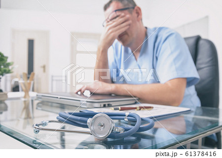 Overworked doctor in his office Overworked doctor in his office 61378416