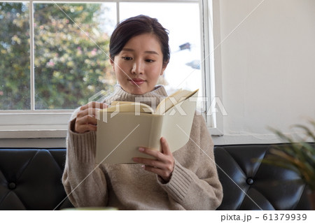 リビングで読書する若い女性 61379939