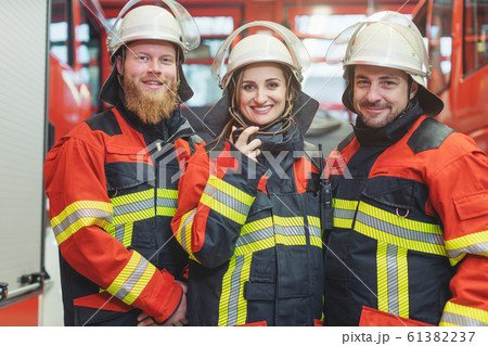 Team of fire fighters looking into camera Team of fire fighters looking into camera 61382237