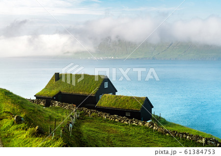 Foggy morning view of a house with typical grass roof 61384753