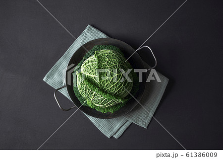 Savoy cabbage in an iron pan on black table. Savoy cabbage in an iron pan on black table. 61386009