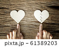woman hand select between heart and broken heart paper cut on wooden background 61389203
