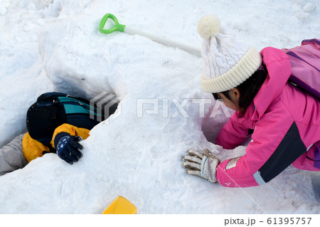雪のトンネルを貫通させて雪遊びをする子どもたち 雪のトンネルを貫通させて雪遊びをする子どもたち 61395757