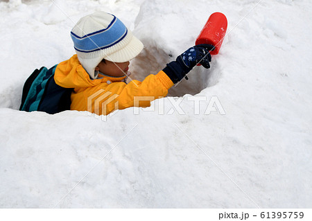 雪山を掘ってどこまで掘れるか挑戦している男の子の楽しい雪遊び 雪山を掘ってどこまで掘れるか挑戦している男の子の楽しい雪遊び 61395759