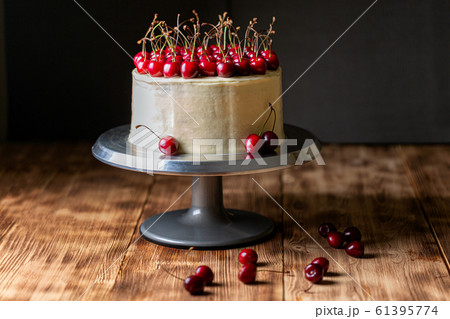 Red velvet cake with sweet cherry on a wooden table 61395774