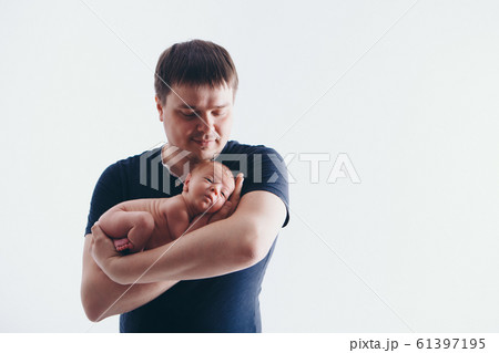 Dad holds the baby in his arms. The concept of educating the father of young children, Happy childhood, a friendly family. Isolated on white background. Copy space Dad holds the baby in his arms. The concept of educating the father of young children, Happy childhood, a friendly family. Isolated on white background. Copy space 61397195