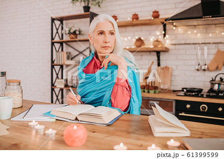 Grey-haired beautiful elderly lady in blue shawl looking thoughtful 61399599