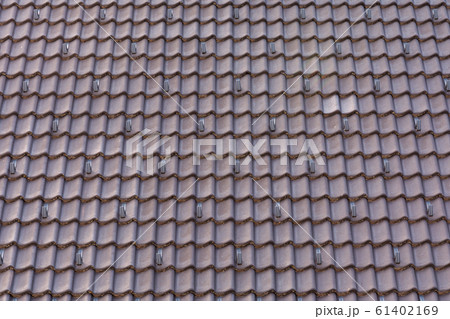 View of the red tiled roof on which hooks are fixed to prevent the avalanche from coming off. Build concept, texture. 61402169