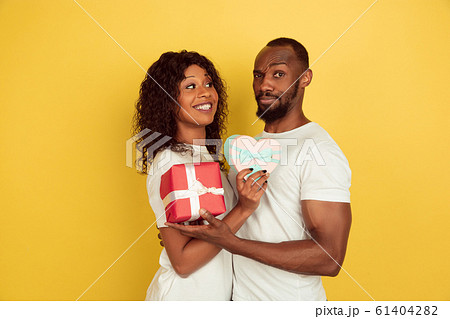 Valentine's day celebration, happy african-american couple isolated on yellow background 61404282