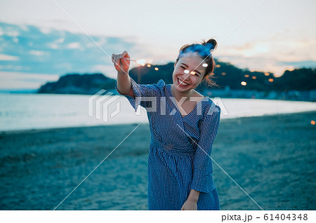 海で花火をする女性の写真素材