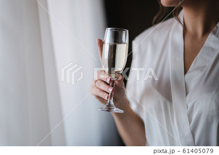 Portrait of gorgeous bride at hotel in morning. Charming woman with glass of champagne Portrait of gorgeous bride at hotel in morning. Charming woman with glass of champagne 61405079