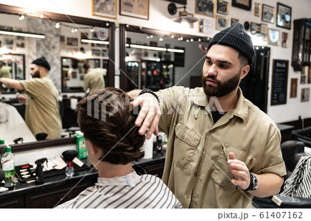 The client receives a haircut and hair styling in a beauty salon. The client receives a haircut and hair styling in a beauty salon. 61407162
