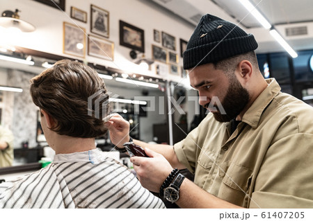 The client receives a haircut and hair styling in a beauty salon. The client receives a haircut and hair styling in a beauty salon. 61407205