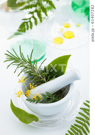 White mortar and pestle with herbs. 61407282