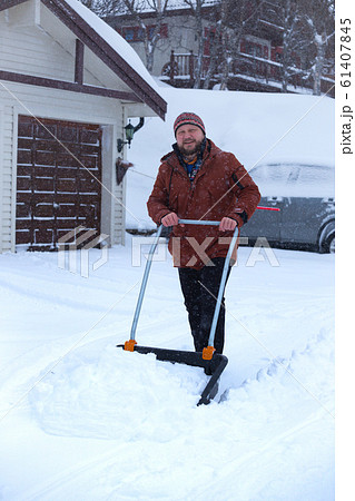 man cleans snow with a shovel man cleans snow with a shovel 61407845